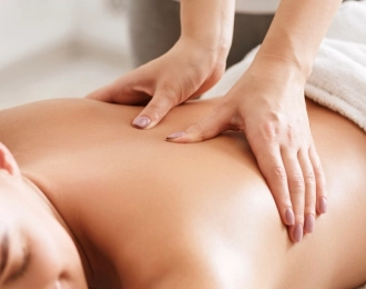 Close-up of a woman laying on her stomach receiving a deep tissue massage.
